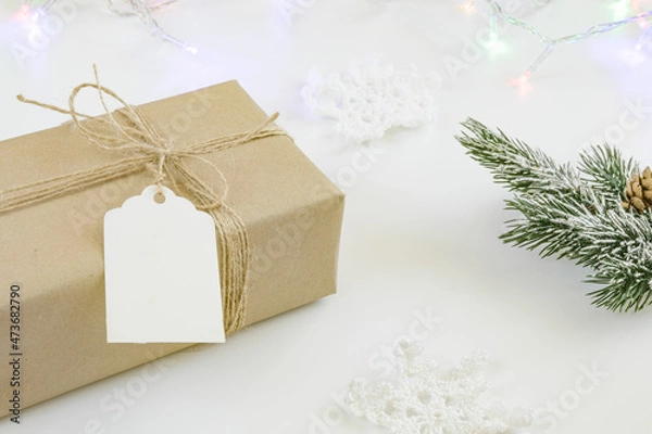 Fototapeta Close up of vintage craft gift with rope and blank label isolated on white background. Spruce branch, garland, christmas gift