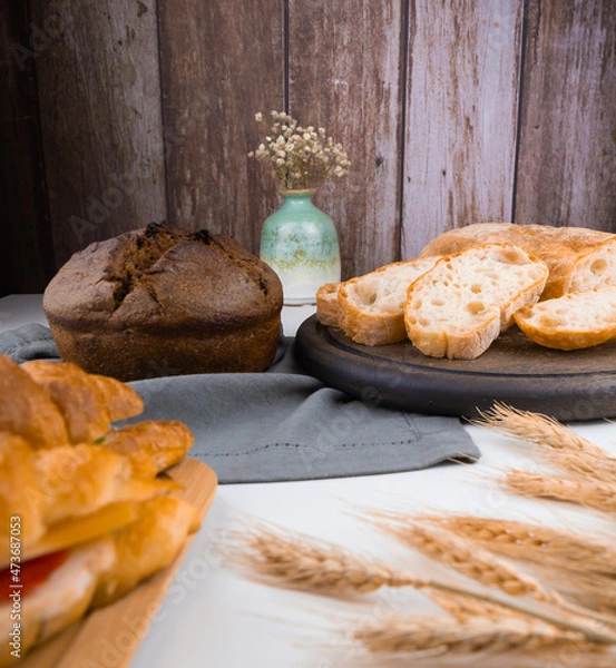 Fototapeta bakery - rustic crusty loaves of bread on wooden background