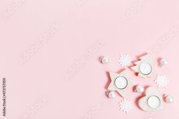 Fototapeta Christmas ornaments and decorations. white snowflakes and white candles on pink background. Minimal flat lay