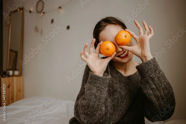 Obraz woman with mandarins at home