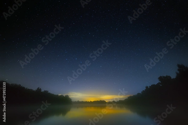 Obraz Night sky with bright stars over the river with fog. Summer landscape in Russia.