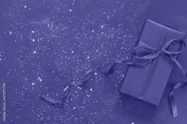 Fototapeta Trendy Color of Year 2022 Very Peri. Purpule gift box with bow on trendy color background with little sparkles. Flat lay style.