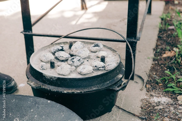 Fototapeta dutch oven covered with light gray coals for cooking in it