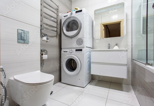 Fototapeta A modern bathroom with Laundry space with washing machine and dryer.
