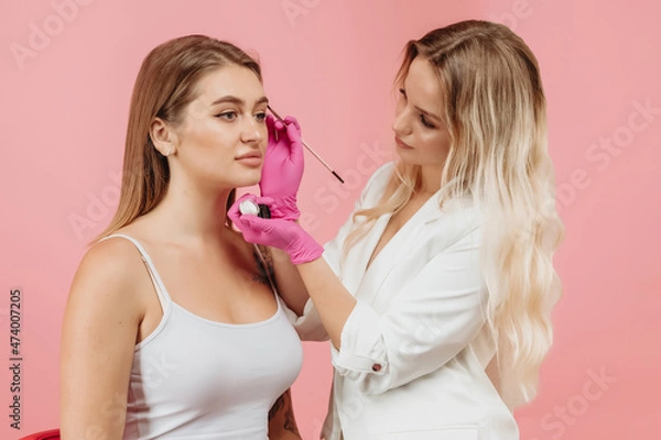 Obraz girl draws eyebrows of the model
