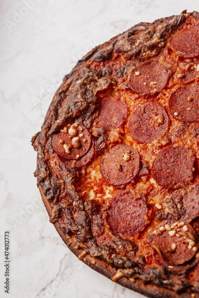 Fototapeta pepperoni pizza on marble counter
