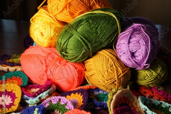 Fototapeta Colorful knitting wool yarn balls and skeins of yarn, hobby material. Handmade knitted, crocheted doily in various colors.