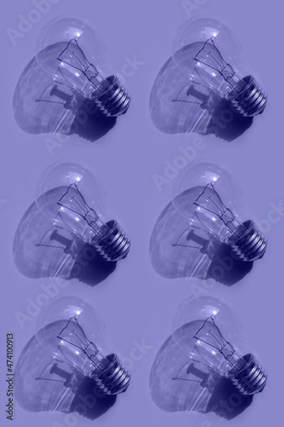 Fototapeta light bulb pattern on a lilac  background. Toned in trendy Very Peri color of the Year 2022