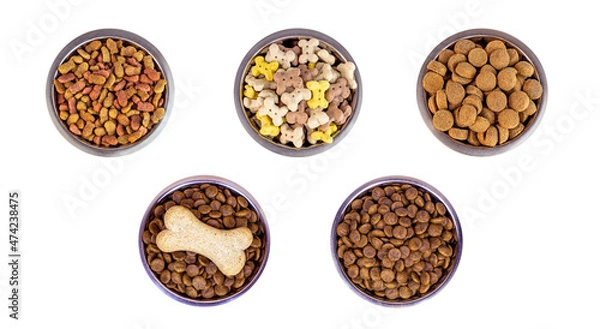 Fototapeta Top view of brown biscuit bones and crunchy organic kibble pieces for dog feed in a metal bowl set isolated on white background. Healthy dry pet food concept.