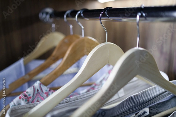 Fototapeta Color clothes hang on clothing rack in a wooden cabinet with lighting in the house