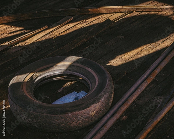 Fototapeta old tire on the floor of an abandoned building