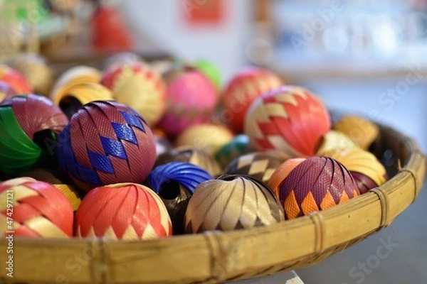 Fototapeta Decorative rattan wicker balls with colorful patterns on a woven winnowing tray basket