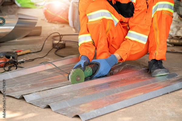 Obraz Construction worker cut the roofing sheet