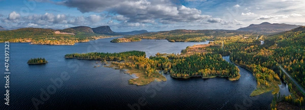 Fototapeta Wild landscape with lake and mountains in autumn in Lapland in Sweden from above during day with blue sky.