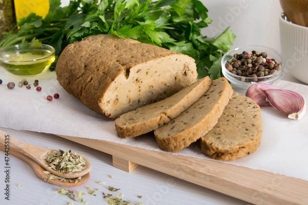 Obraz seitan or vegan meat sliced with spices such as oregano, pepper, garlic, and parsley.