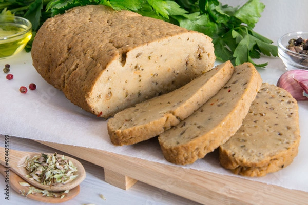 Obraz seitan or vegan meat sliced with spices such as oregano, pepper, garlic, and parsley.