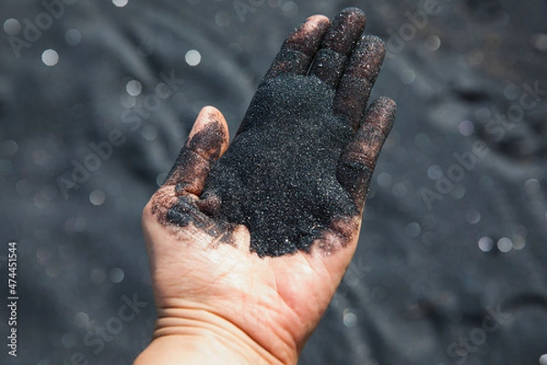 Obraz Volcanic sand falling from hand, close-up