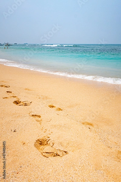 Fototapeta Beach by the ocean with yellow sand in the tropics.