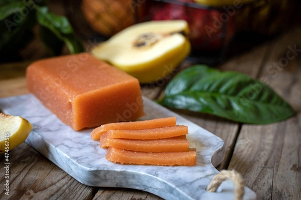 Fototapeta Quince marmalade, with commbert cheese, on a marble board with quince pieces.