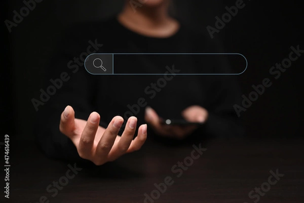 Fototapeta Woman holding smart phone with search bar icon. Networking Concept.