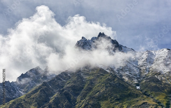 Fototapeta Clouds around mountain peak on summer day