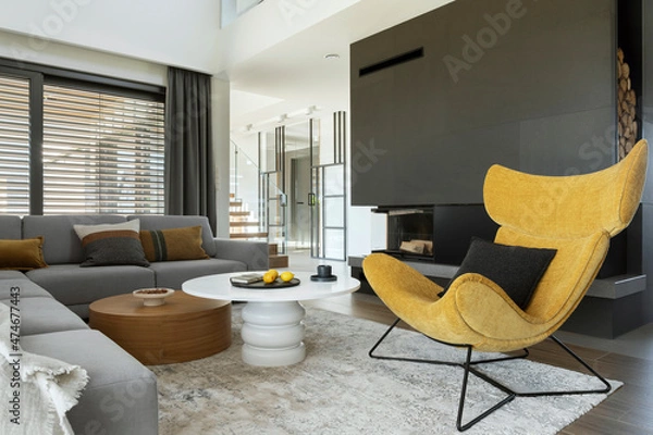 Fototapeta Modern living room interior design with corner beige sofa,  rounded coffee tables, mustard armchair, fireplace and accessories.  Template. .