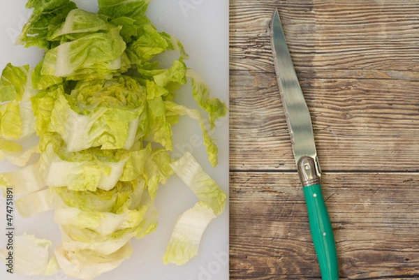 Fototapeta Lechuga fresca, picada en una tabla de cortar, cuchillo verde, vista superior