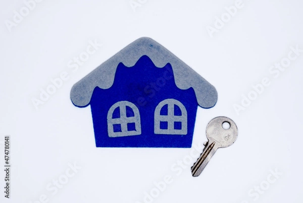 Fototapeta Handmade flat toy in form of house with white roof and windows on it and key