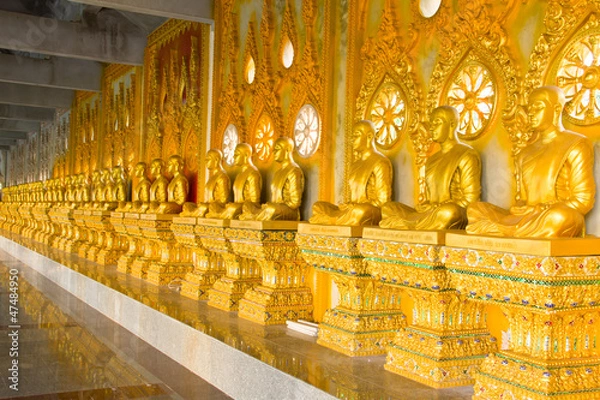 Fototapeta row of golden monk buddhist statues in thai temple, Chaimongkhol