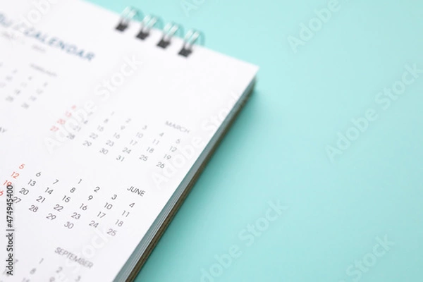 Fototapeta calendar page on blue background business planning appointment meeting concept