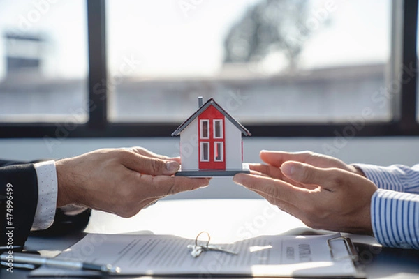 Fototapeta Real estate agents handing over Example of a house and a house price contract agreement Before handing over the house and keys to the customer, the concept of mortgage, purchase and home insurance.