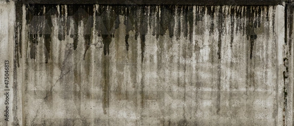 Fototapeta Texture of grey concrete wall with dark water and oil marks running vertically down and many marks and lines