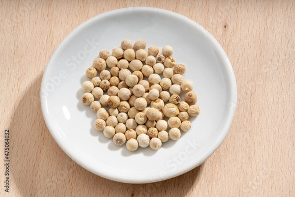 Fototapeta Detailed and large close up shot of peppercorns on a small plate