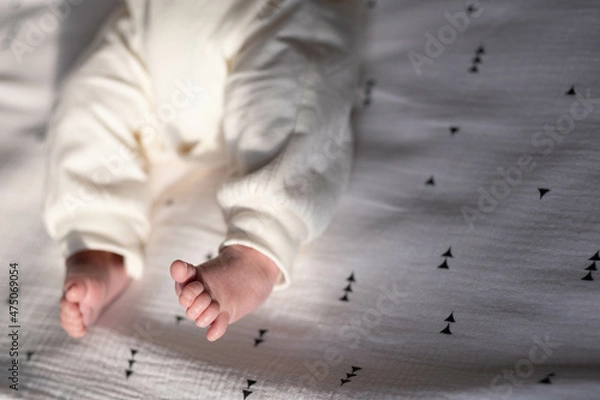 Obraz Charming legs of a newborn baby lying on a light bed