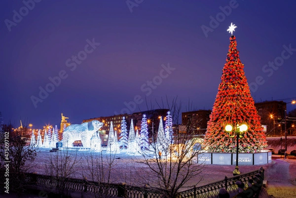 Fototapeta Moscow, Russia - December 14, 2021: Christmas tree and installation in Rostokinsky Aqueduct Park.
 A three-dimensional decorative installation of the bear "Umki" and a Christmas tree appeared on the R