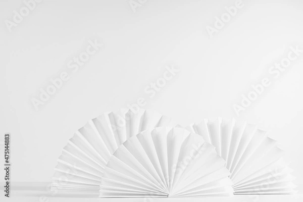 Fototapeta White soft light chinese circle folds paper fans on table with wall as as decoration in elegant asian abstract background, copy space.
