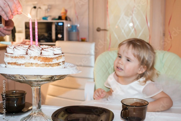Fototapeta Birthday of a two-year-old girl, an appetizing cake with two burning candles