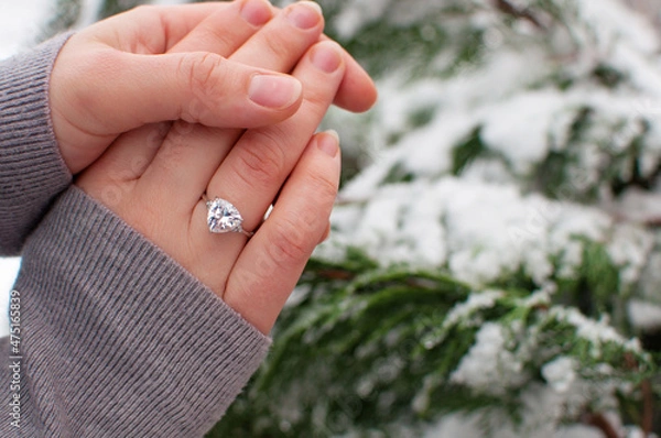 Fototapeta women's hands with a ring with a large gemstone on a blurred background with a place for text