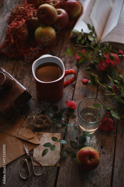 Fototapeta A mug of tea on a wooden background, old envelopes, flowers in retro style.