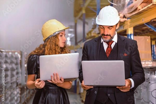 Fototapeta Manager and supervisor discussing work with products in stock and ready to delivery. 