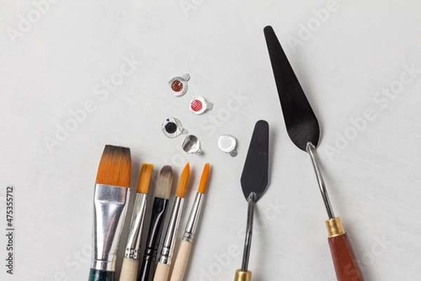 Obraz Foil caps from tubes of paint and a set of art brushes and palette knives