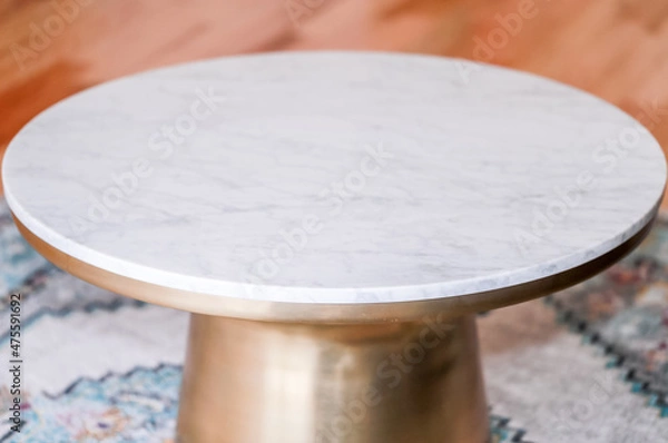 Obraz Modern style coffee table with brass metal base, marble top and wooden background. Round coffee table. Modern - Image