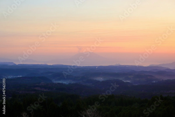 Obraz 夕暮れの空に浮かぶ赤く染まった桜島~霧島側から(小さく飛行機が写っている)