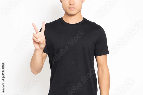 Fototapeta 白い背景の前に立って、手で数字の2を表す黒いTシャツを着ている男性