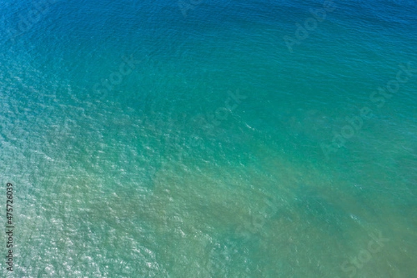 Fototapeta ..aerial view The emerald green waters of the Andaman Sea. .Wave after wave swept towards the shore. .emerald green sea, blue sea, and clear sand landscape. Paradise beach..