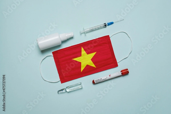 Fototapeta Blood tube for test detection of virus Covid-19 Omicron Variant with positive result, medicine mask with Vietnam flag superimposed and vaccine.  New Variant of the Covid-19 Omicron