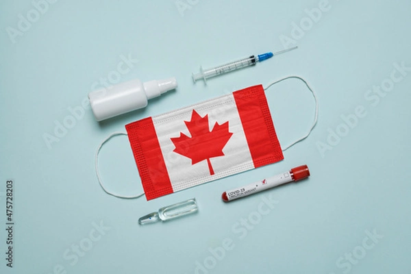 Fototapeta Blood tube for test detection of virus Covid-19 Omicron Variant with positive result, medicine mask with Canada flag superimposed and vaccine.  New Variant of the Covid-19 Omicron
