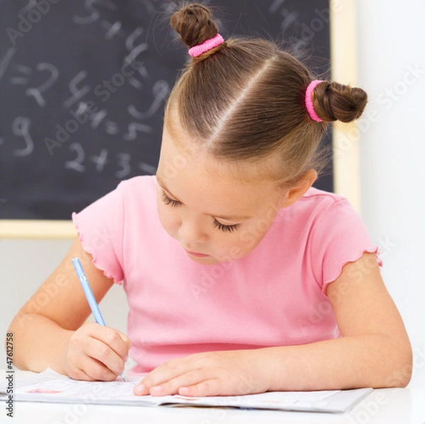 Obraz Little girl is writing using a pen