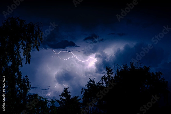 Obraz Night sky with lightning in a thunderstorm. Dramatic weather.