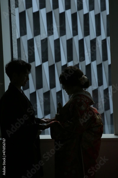 Obraz 結婚式後の控室で窓辺に立つ夫婦